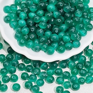 Detailed macro view of emerald green translucent cat eye glass beads for DIY jewelry