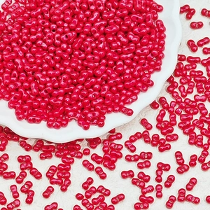 Vibrant red peanut glass seed beads with dual holes for handmade jewelry making and DIY projects