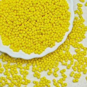 Premium yellow 3x6mm glass twin seed beads for DIY jewelry making in a white ceramic bowl