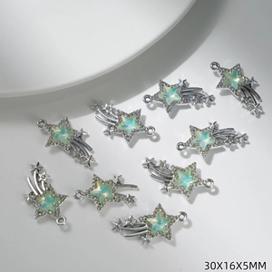 Detailed close-up of shiny star-shaped jewelry charms with pale green stones and rhinestones