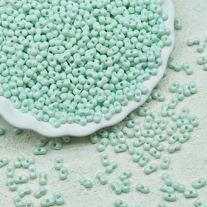 Macro view of mint green two-hole peanut glass seed beads for DIY jewelry making
