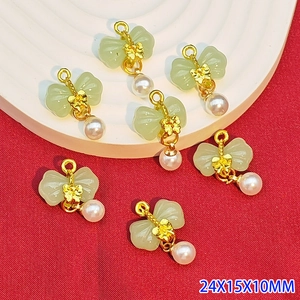Macro detail of alloy butterfly pendants with faux jade stone and small pearl drops