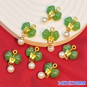 Detailed view of green resin butterfly pendant with pearl and golden alloy ring