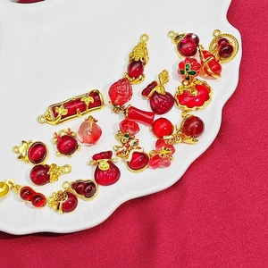 Dettaglio di ciondoli a quadrifoglio rosso e oro per la creazione di gioielli fai da te