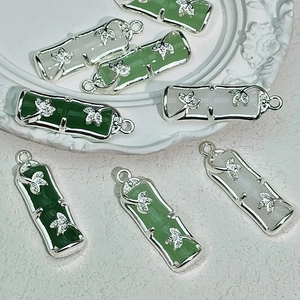 Detailed view of bamboo joint charms in jade-like glass and silver for DIY jewelry