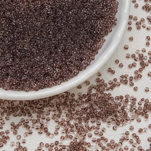 Macro shot of 3mm dark brown translucent glass seed beads for DIY jewelry making projects