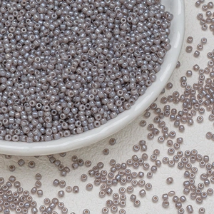 Makroaufnahme von perlmuttfarbenen 3mm Glasperlen in einer weißen Keramikschale