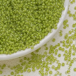 Macro shot of 3mm lime green translucent glass seed beads for DIY jewelry making