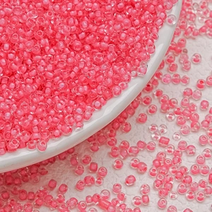 Macro shot of transparent pink 3mm glass seed beads for DIY jewelry and embroidery