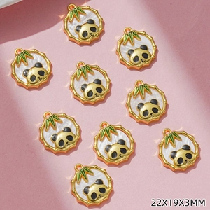 Dettaglio del set di ciondoli panda e bambù con misure 22x19x3mm su sfondo rosa