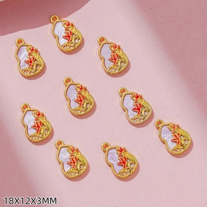 Detailed view of ten 18x12x3mm golden gourd pendants with red enamel and purple inlay