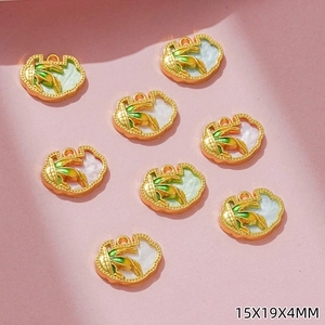 Detail of corn-shaped golden alloy charms with yellow enamel for DIY jewelry making