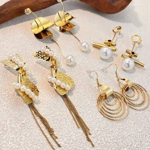 Elegante set di orecchini con foglie dorate e perle in un display artistico naturale