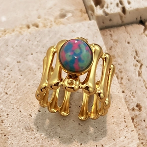 Anello regolabile in oro a strati di ossa con pietra naturale colorata su sfondo di pietra