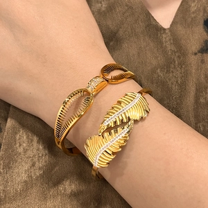 Set di bracciali dorati in acciaio inossidabile con motivi piuma, ventaglio e cristalli