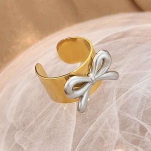 Two-tone 18K gold and silver bow ring in stainless steel with an open adjustable band