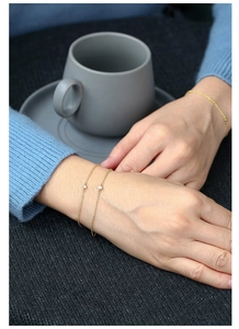 Makro-Detail minimalistischer vergoldeter Zirkon-Armbänder im modischen Layering-Stil