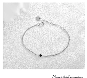 Detailansicht eines minimalistischen Silberkettenarmbands mit schwarzem Zirkonstein