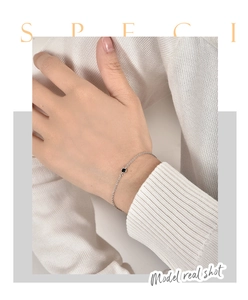 Detailaufnahme von minimalistischem Silberkettenarmband mit schwarzem Zirkon am Handgelenk