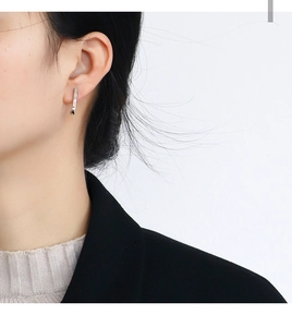 Minimalist silver geometric bar drop earrings on model in black suit and white background