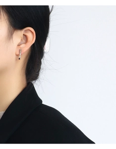 Detail of silver bar earring with a round diamond stud worn by a model in a minimalist style