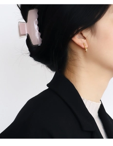 Minimalist gold hoop earring with small zircon on model with a beige hair claw clip