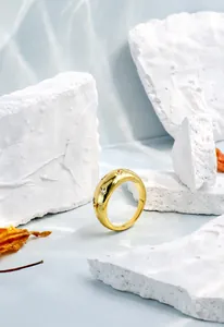 Detalle de anillo de estrella dorado con circonitas blancas sobre piedra texturizada