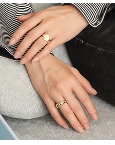 Primer plano de anillos dorados con circonitas en forma de estrella en una mano