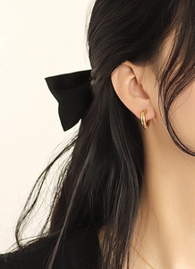 Close-up of 18K gold plated hoop earrings worn by a model for a minimalist fashion look