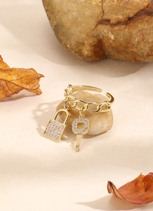 Dettaglio dell'anello a catena in oro 18 carati con ciondoli a lucchetto e chiave