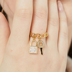 Anello a catena in oro 18K con ciondoli a lucchetto e chiave in zirconi cubici sulla modella
