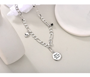 Detail van Figaro-ketting met schedel en Here for the Boos hanger op een wit decorstuk