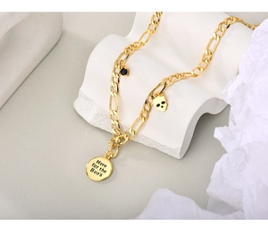 Detail van gouden Figaro-ketting met schedel hanger en Here for the Boos-bedeltje