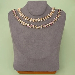 Double-layered gold-plated chain necklace with colorful faceted crystals on a grey bust display