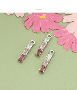Macro shot of 18k gold-plated bamboo-style pendants with pink gradient zircon stones