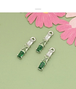 Macro detail of three rectangular gradient green zircon bamboo charms for DIY jewelry making