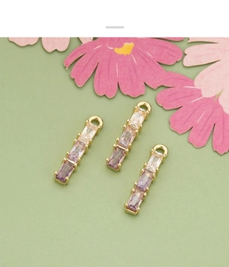 Close-up of three 18k gold-plated bamboo pendants with gradient zircon for jewelry making