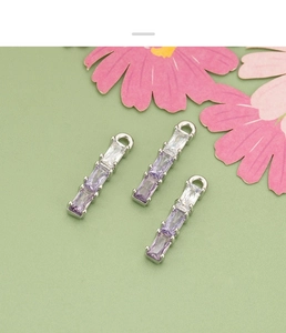Detailed macro view of three gradient purple cubic zirconia bamboo pendant charms for DIY