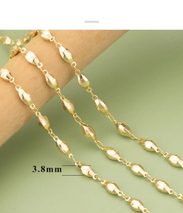 Detail of 3.8mm faceted olive bead chain with 18K gold plating on a wooden rod