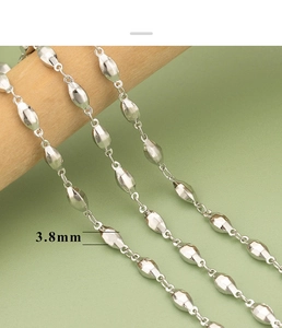 Macro view of 3.8mm polished silver olive bead chain necklace with metal texture details