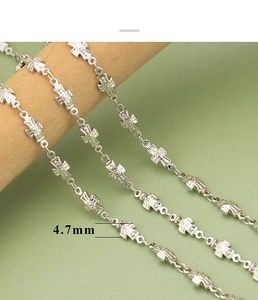 Macro detail of 4.7mm silver cross link chain with textured surface on wooden display
