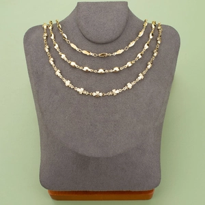 Three-layered 18K gold-plated chain set featuring cross, bead, and leaf designs on display