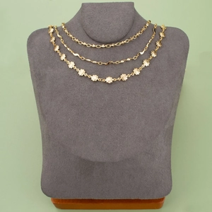 Three layers of 18k gold plated geometric chains and floral link necklaces on display