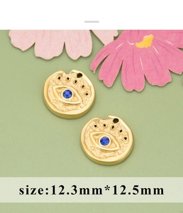 Macro shot of gold evil eye charms with blue crystal for DIY jewelry making 12.3mm