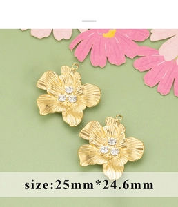 Detailweergave van twee gouden bloemenhangers met strassteentjes en 25 mm maat