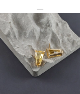 Vista macro degli orecchini a trapezio in vetro giallo con anello fai-da-te placcato oro 18K