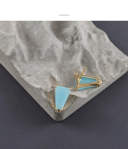 Dettaglio macro del ciondolo a trapezio in vetro azzurro con perni per orecchini placcati oro 18K
