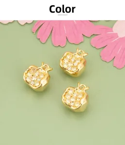 Detailed close-up of three pomegranate-shaped 18K gold pendants with inlaid zircons