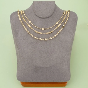 Three-layer gold floral bead necklace set displayed on a grey textured mannequin stand