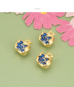 Detailed view of apple-shaped 18K gold plated charms with blue cubic zirconia stones